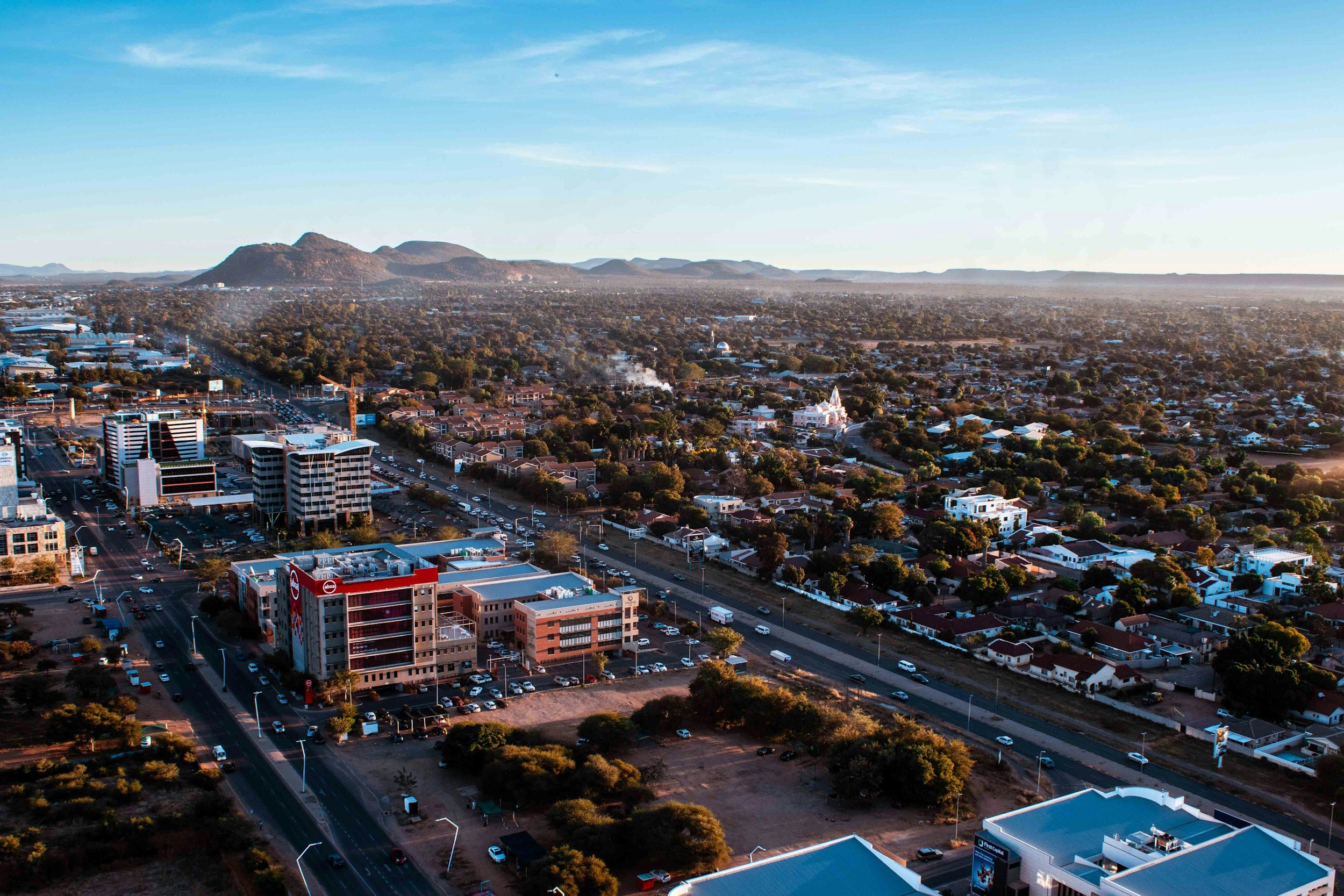 An aerial view of Gaborone’s central business district, with homes, tree-lined streets and hills beyond